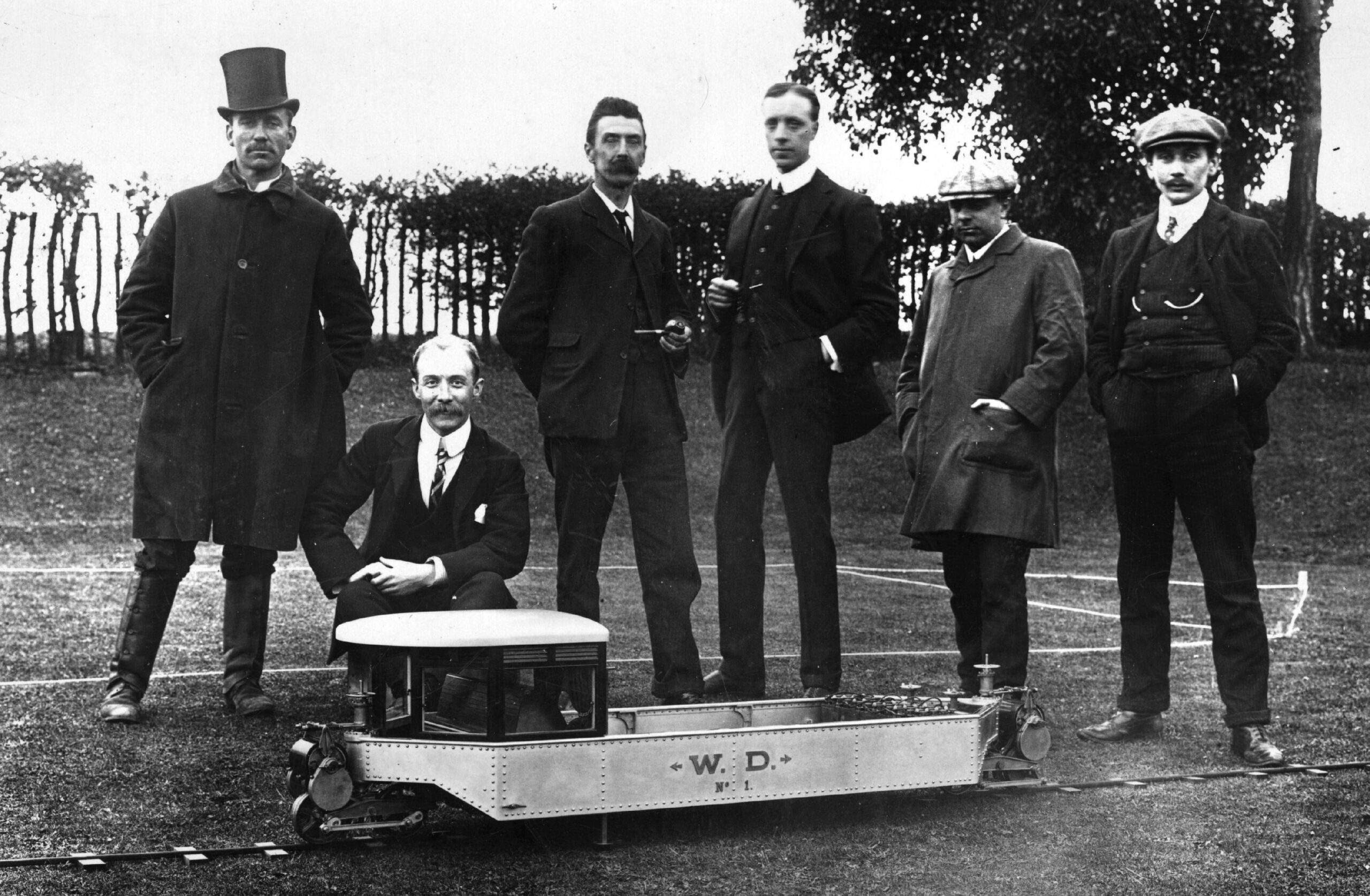 Louis Brennan poses with his assistants behind his model gyro monorail