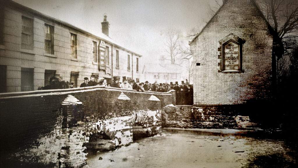 Old photograph of Bow Bridge in the city of Leicester with people on it