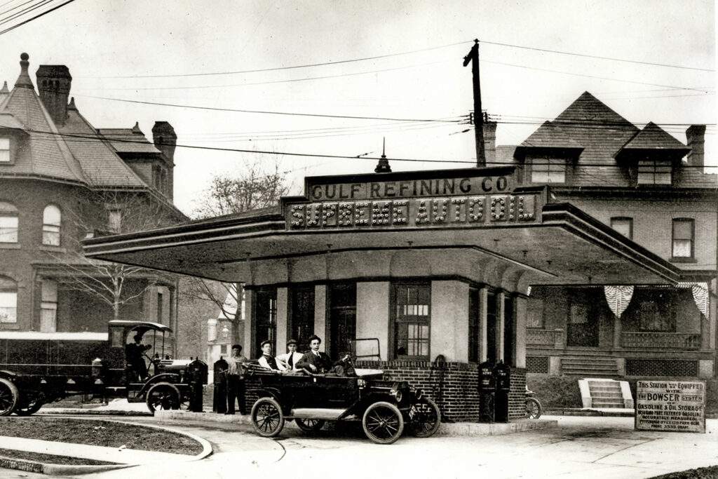 Black and white photo showing people filling up their cars in 1913 at the first ever gas station in Pittsburgh
